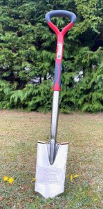 A metal detecting spade stuck in the ground